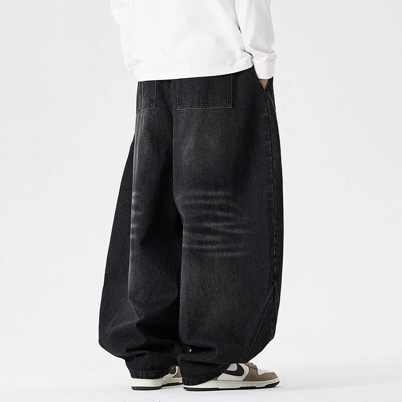 Men's plus-size baggy blue denim jeans with straight leg and low waist on a neutral background.