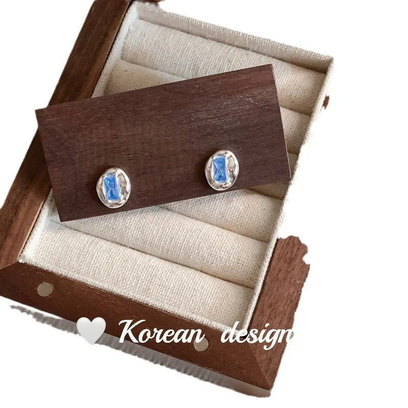 S925 sterling silver oval earrings with heart-wrapped blue diamond design in silver colour