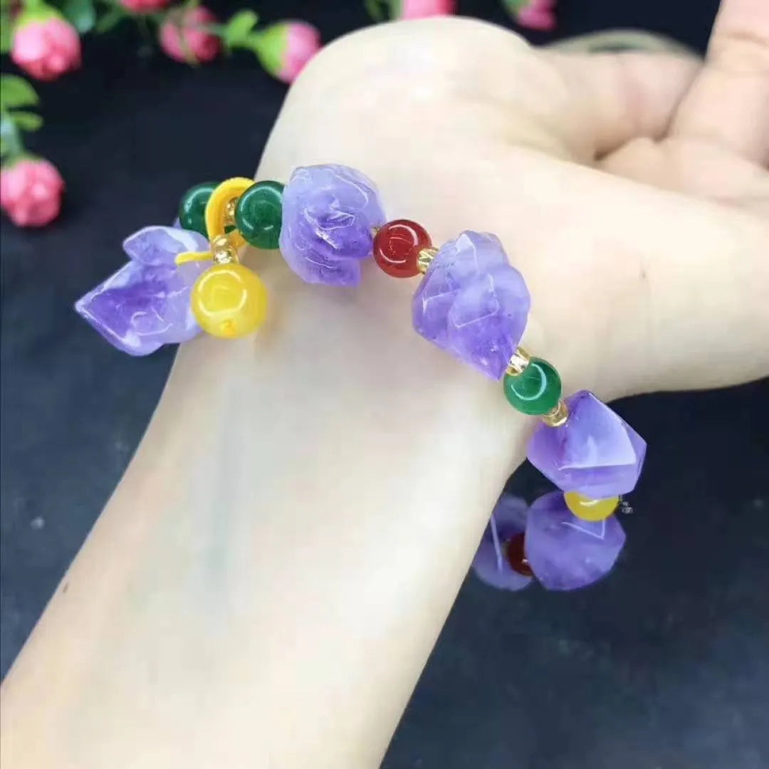 Women's natural shaped violet amethyst bead bracelet with a fu character pendant on a white background.