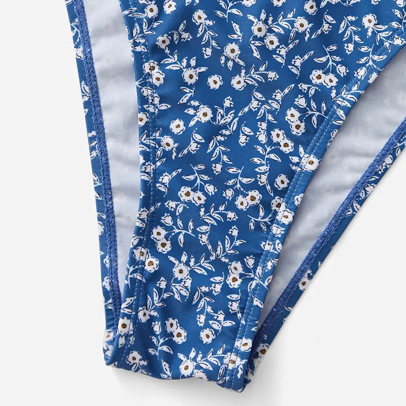 Blue polyester swimsuit three-piece set showing top and shorts, laid flat.