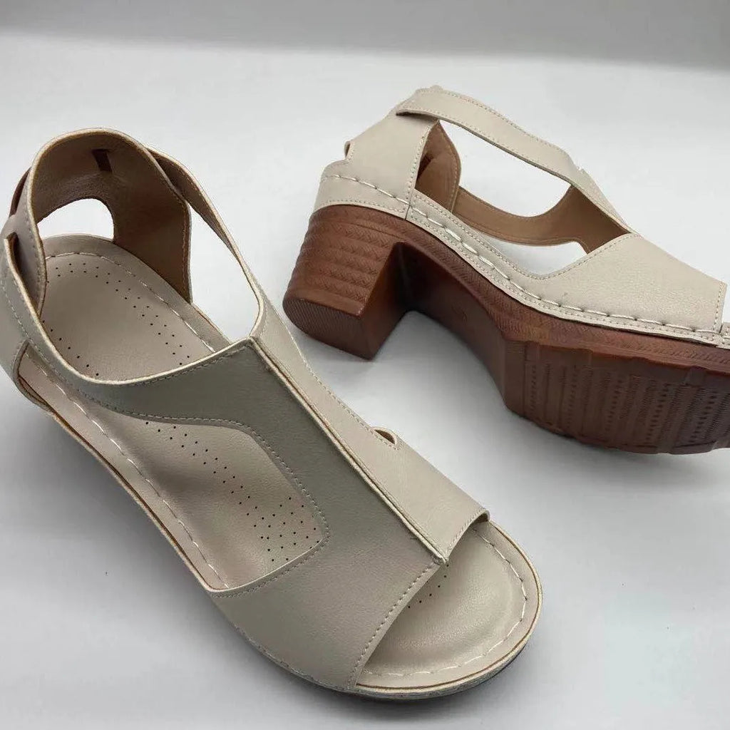 Women's beige peep toe wedge sandals with ankle buckle, shown on a foot.