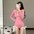 Women's long sleeve one-piece swimsuit in pink on a mannequin.