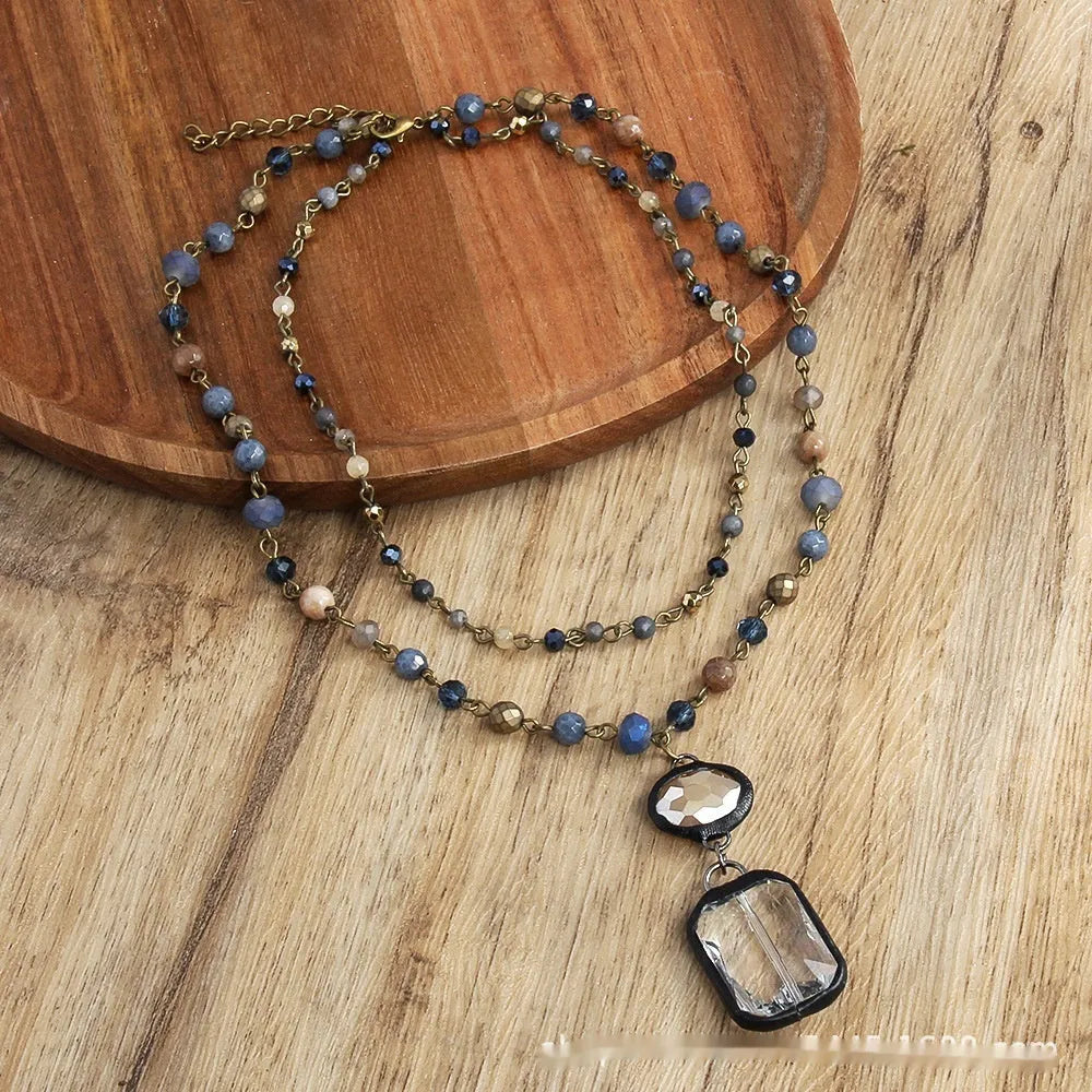 Beige and blue two-layer tribal style necklace with glass pendant and stone accents on adjustable chain