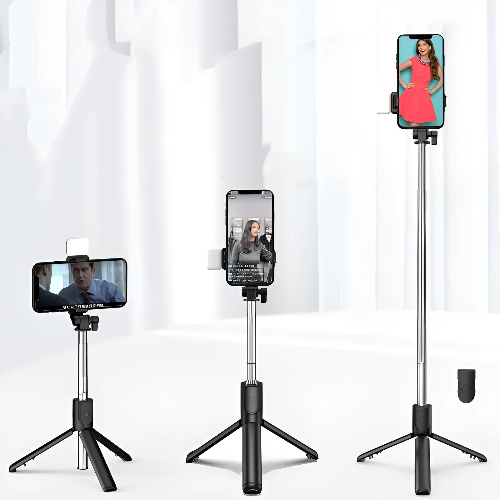 Black Bluetooth selfie stick with extended tripod legs holding an iPhone, showing its 360-degree rotating phone holder.