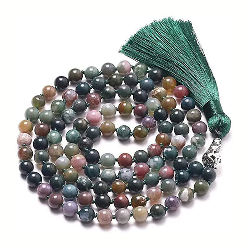 Long beaded agate and amethyst tassel necklace with geometric pendant on a neutral background.