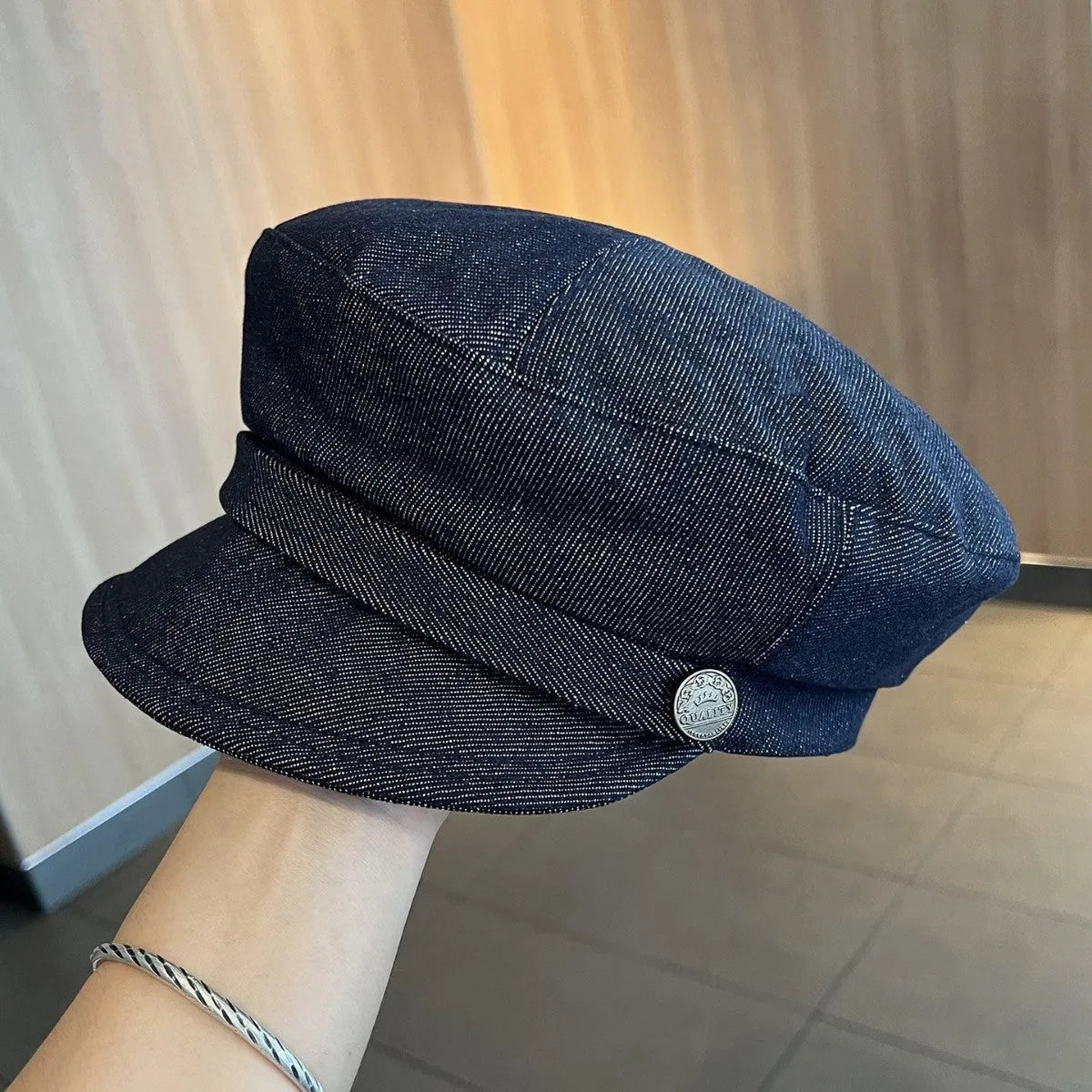 Dark blue denim adjustable octagonal newsboy cap shown on a neutral background.