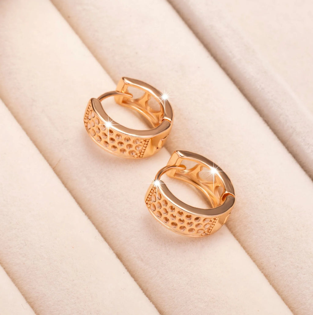 Rose gold coloured earrings with three hollow heart shapes arranged in circular pattern
