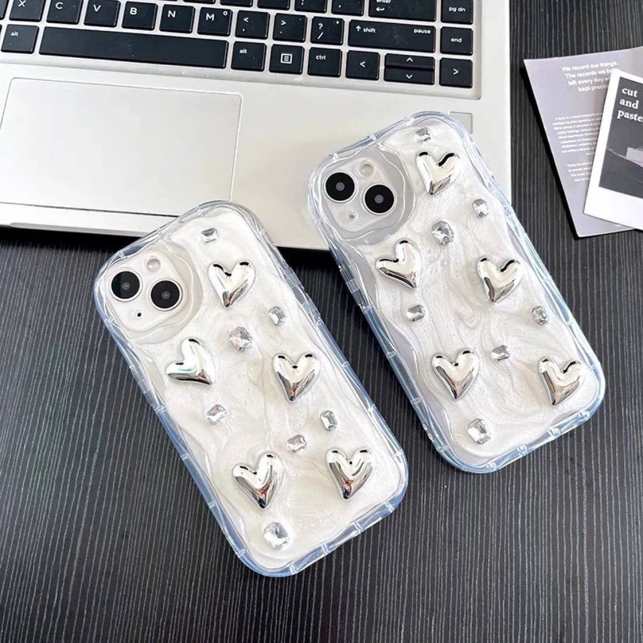 Transparent TPU phone case with three-dimensional silver love gem rhinestone heart design on white background