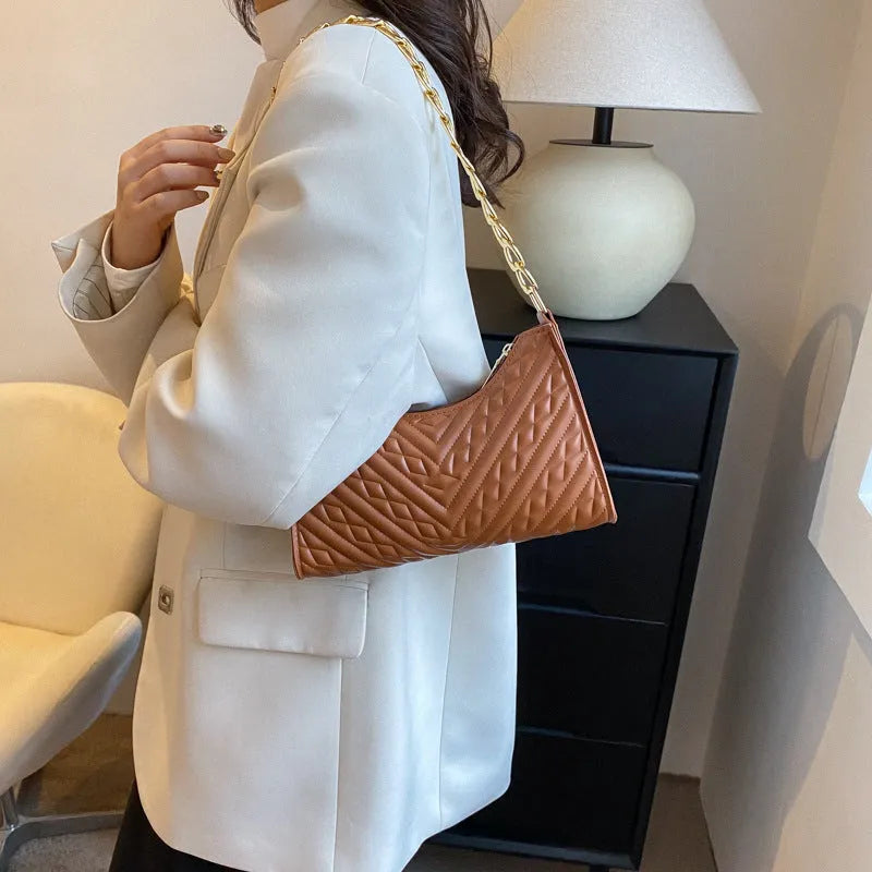 Brown pleated chain shoulder bag with soft handle and adjustable strap showing sewing line detailing
