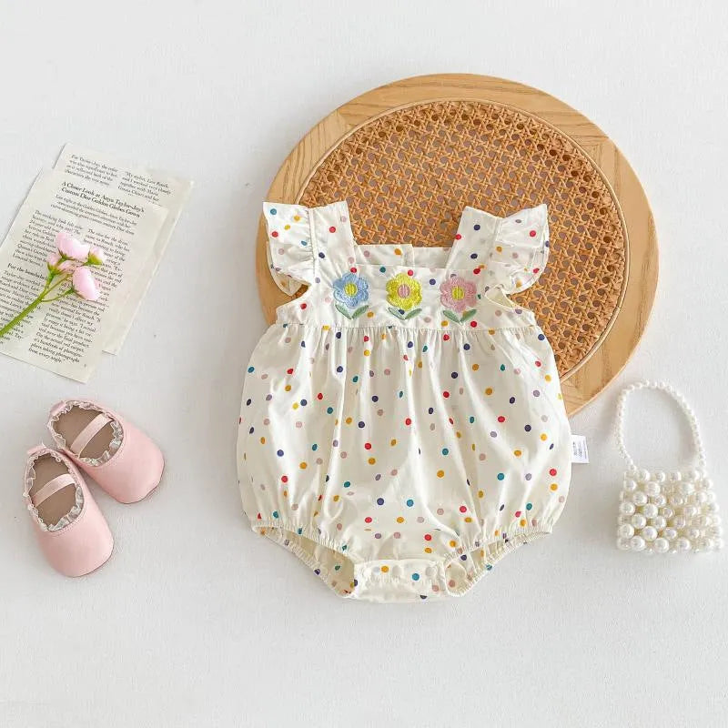 Beige cotton newborn summer jumpsuit with polka dots and flounced sleeves on white background