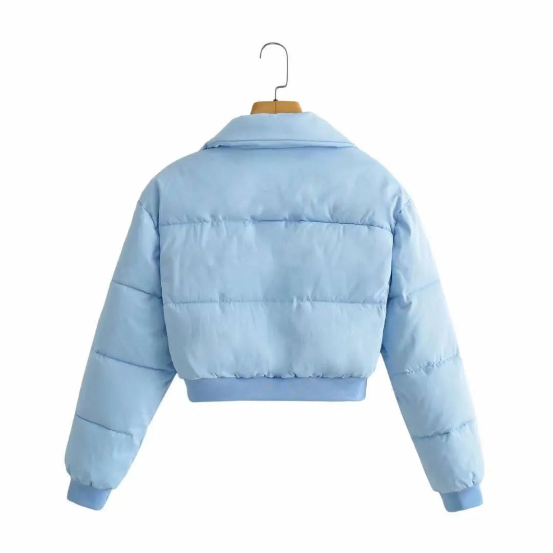 A woman's loose-fitting long-sleeve polyester jacket in blue, shown on a hanger.