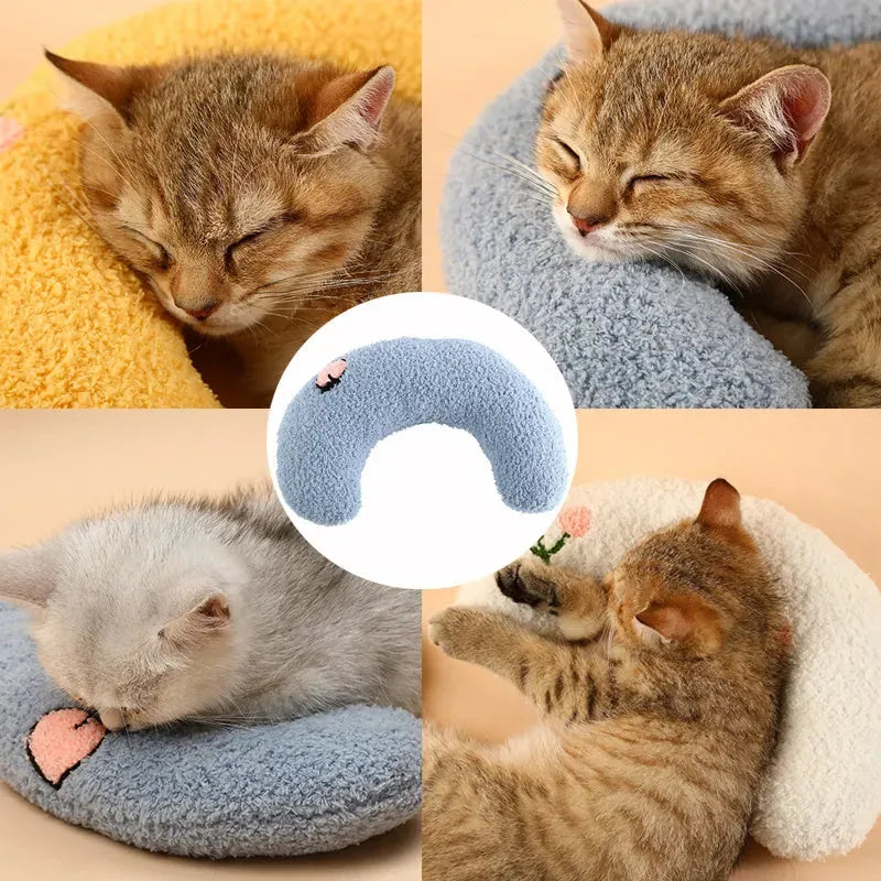 Blue U-shaped plush pet pillow for a small cat or dog on a grey background.