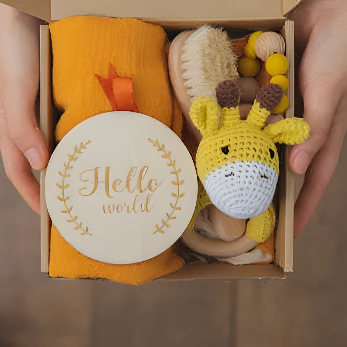 Baby teething toy gift set with bamboo blend gauze blanket, wooden beech bell, teether, brush, and milestone marker.