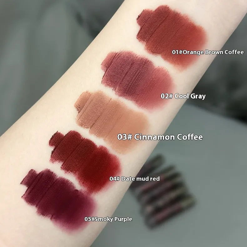 Matte lip mud lipstick in tube showing five colour shades: orange brown coffee, cool grey, cinnamon coffee, jujube red, smoked purple.