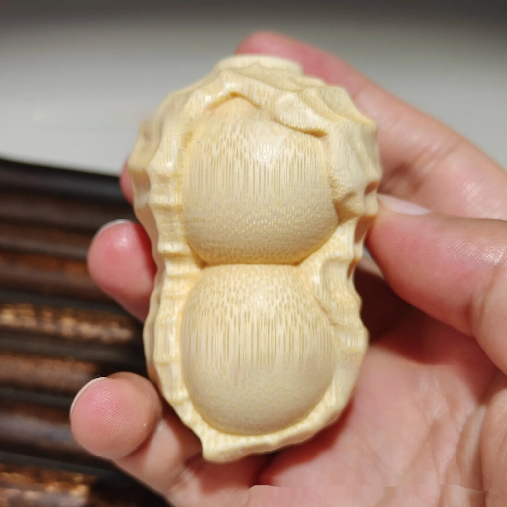 Modern minimalist solid bamboo carving peanut ornament on a neutral background.