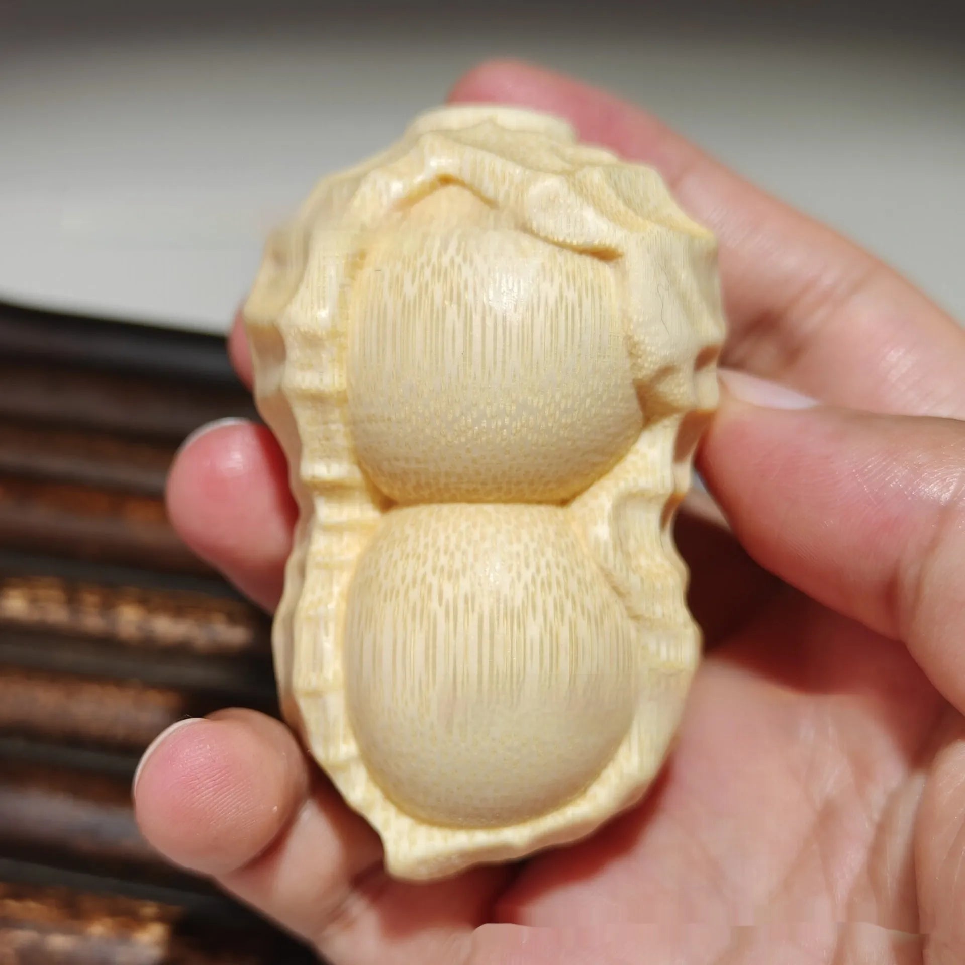 Modern minimalist solid bamboo carving peanut ornament on a neutral background.