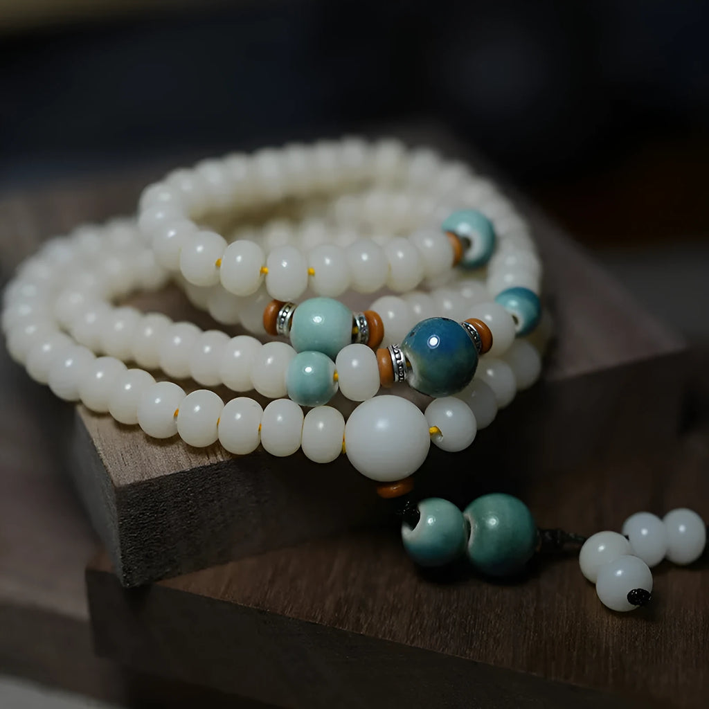 White jade bodhi seed bracelet with 108 flat round beads in two sizes on wrist