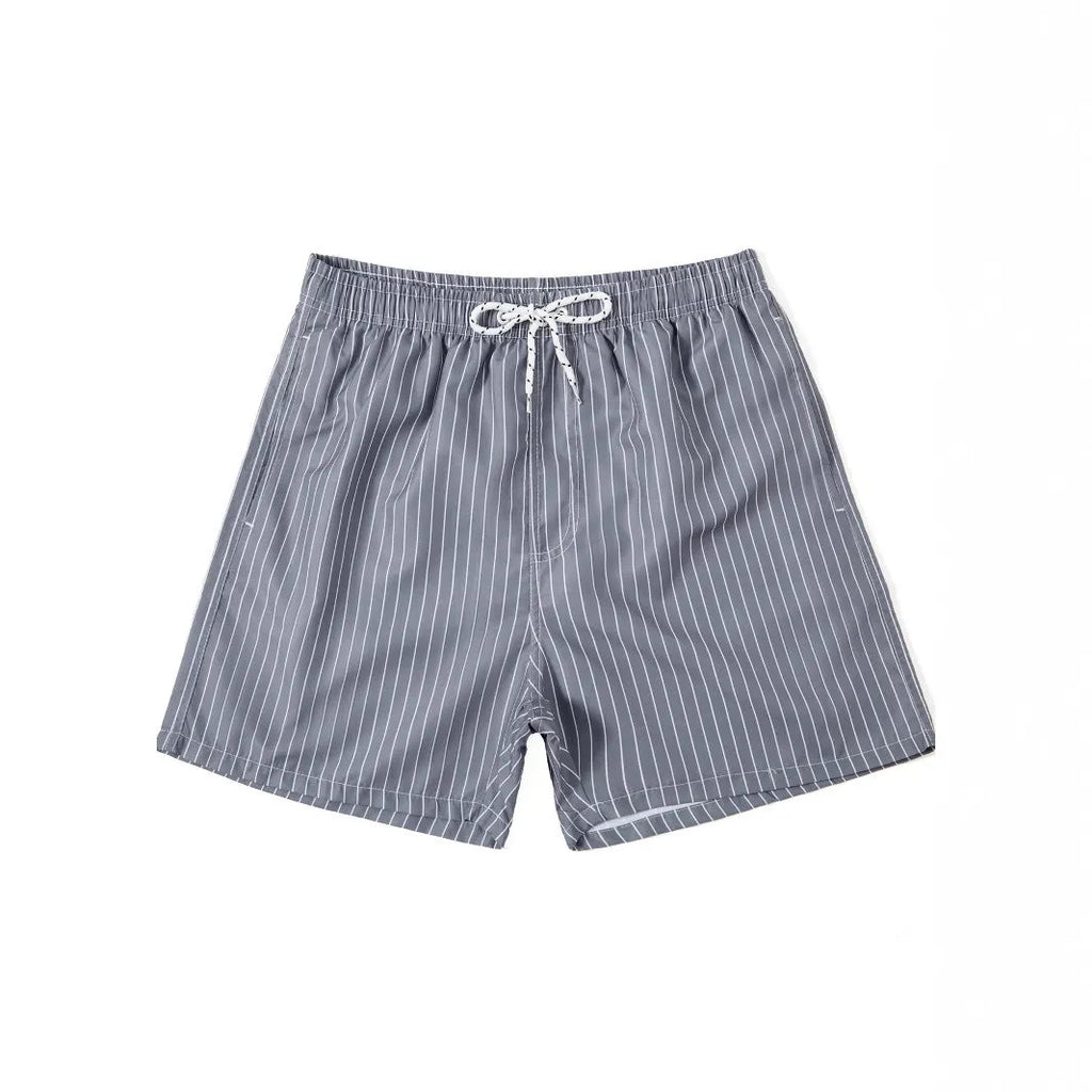 A pair of striped beach shorts in a light blue colour with a straight leg opening, laid flat.