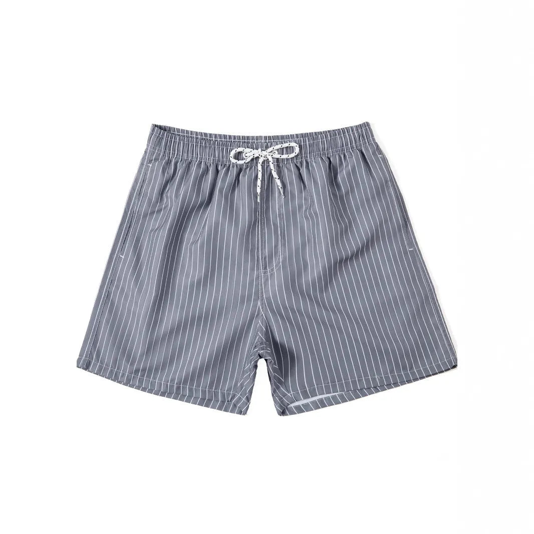 A pair of striped beach shorts in a light blue colour with a straight leg opening, laid flat.