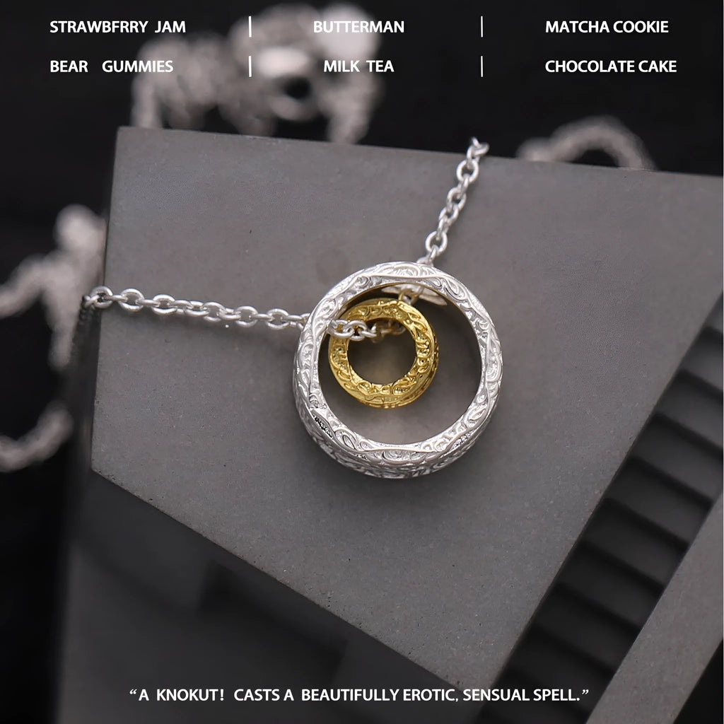 Geometric copper nested necklace with gold and silver electroplated finish, round and ring elements, on display
