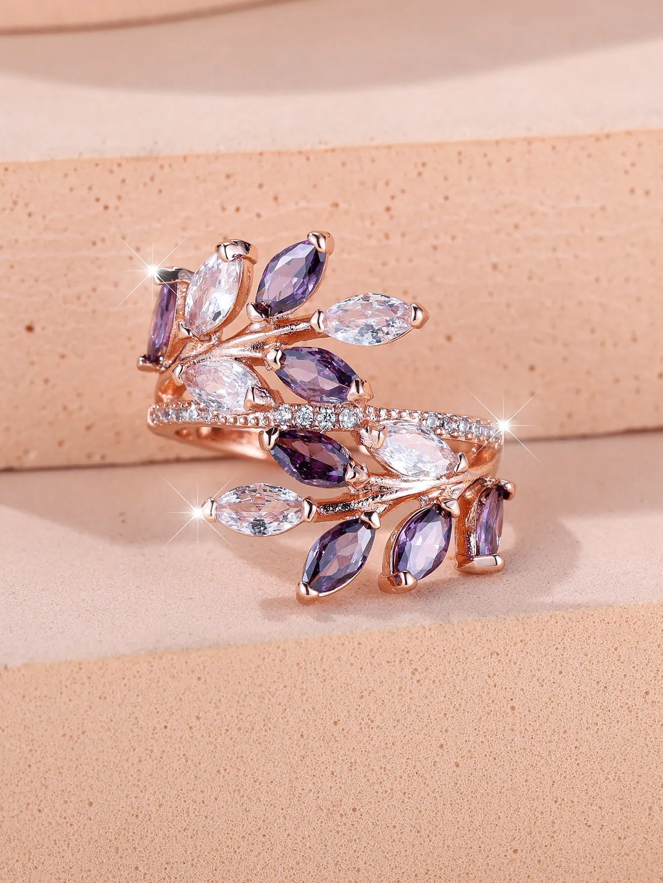 Adjustable leaf ring with horse eye zircon stone in rose gold finish on wooden background