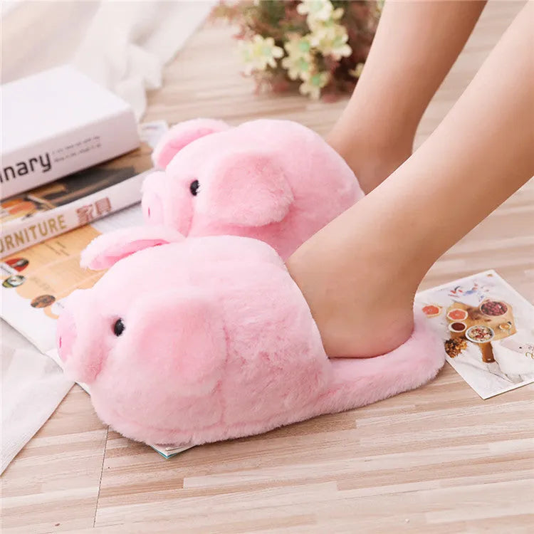 Pink plush pig face design floor slippers on a white background.