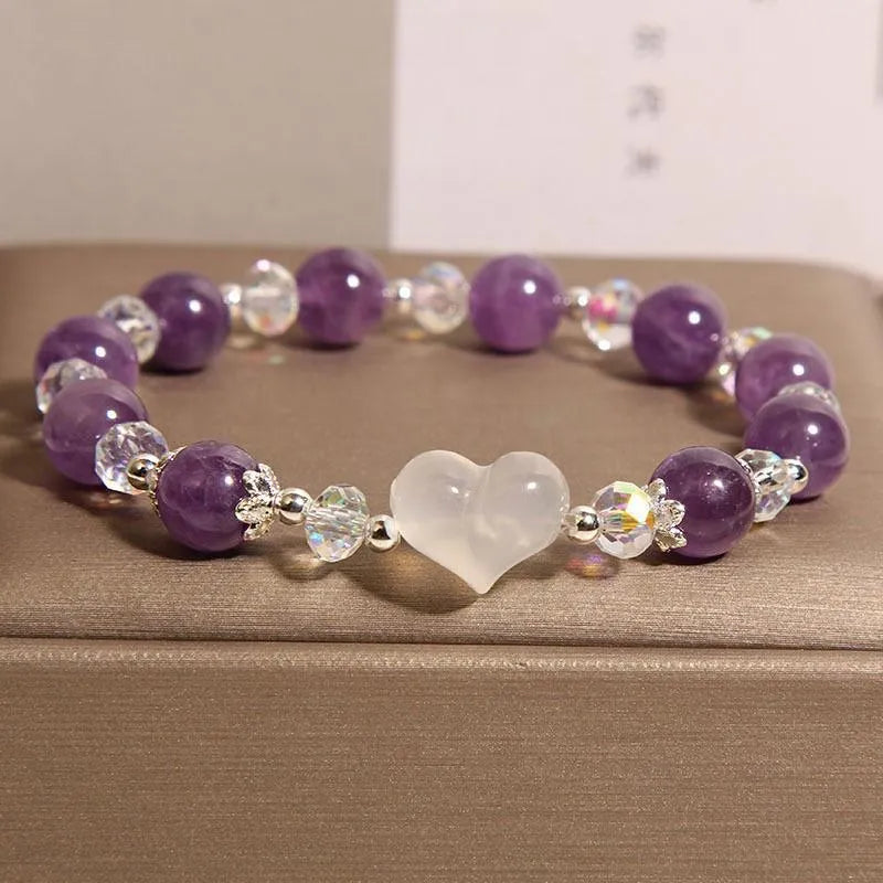Natural amethyst bracelet with white agate love heart charm on a light background