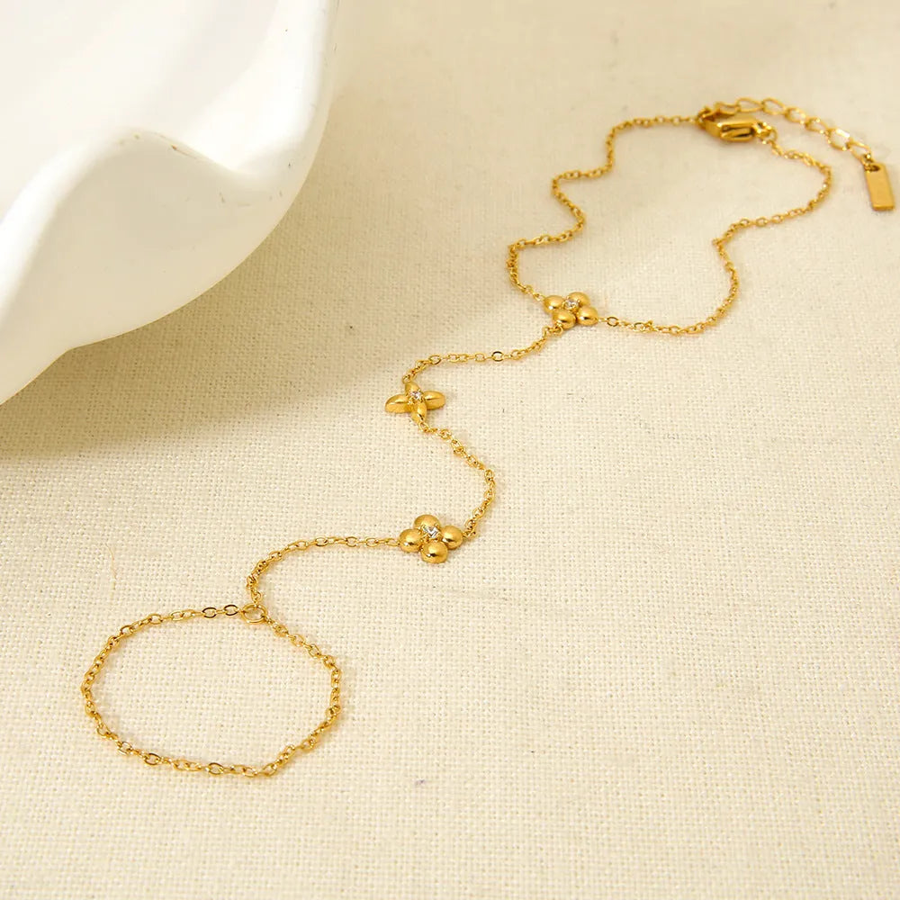 Gold-coloured stainless steel women's bracelet with geometric floral and eight-pointed star design.