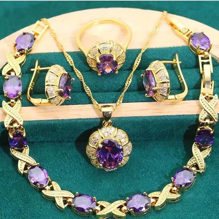 Gold plated cubic zirconia jewellery set with necklace, earrings, ring, and bracelet in blue, green, purple, or red.