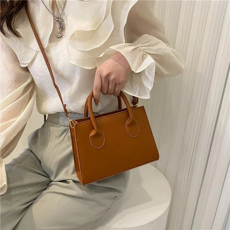 PU synthetic leather small horizontal square shoulder bag in five colour options showing document pocket and single strap