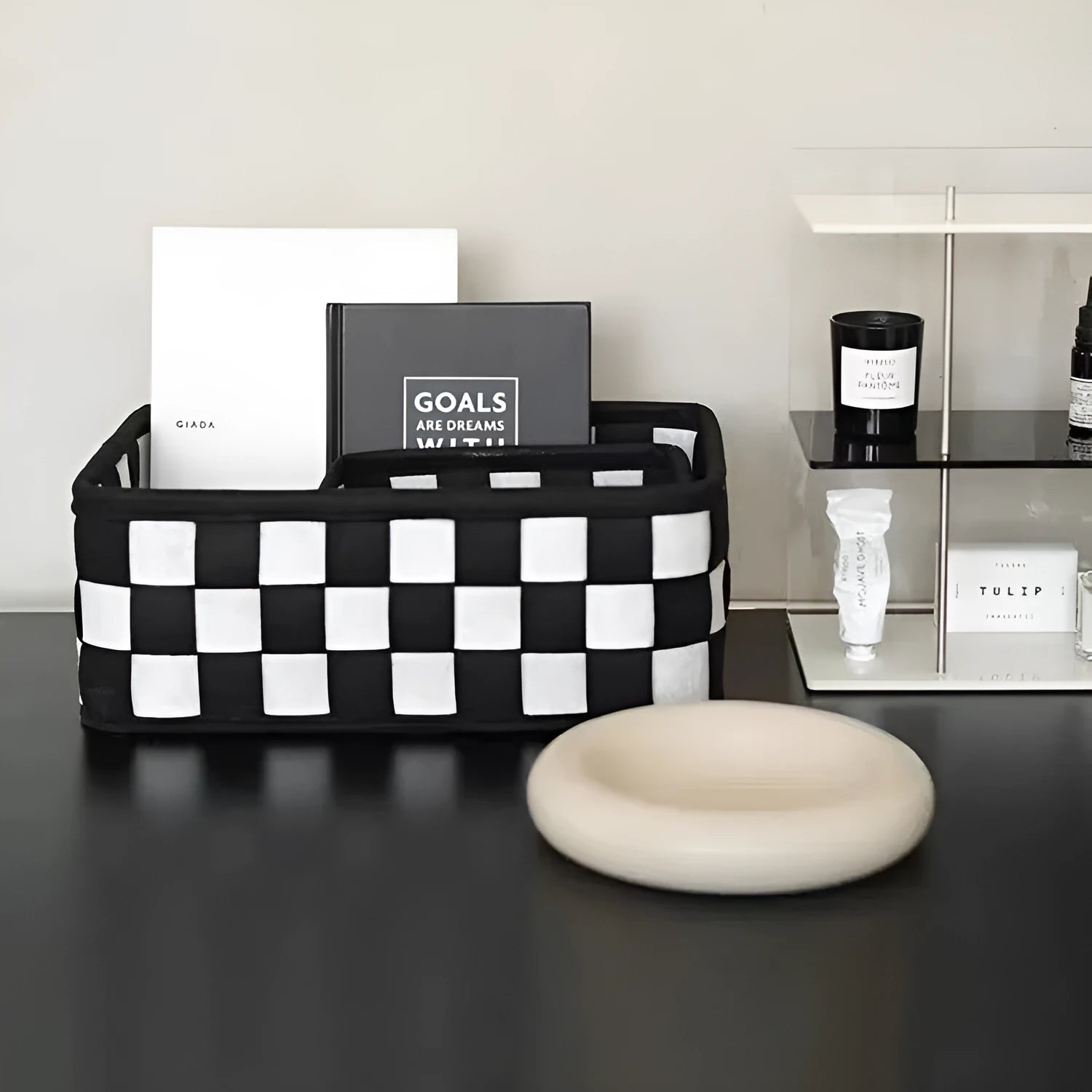 Checkerboard patterned grey felt storage basket with folded sides, shown empty.