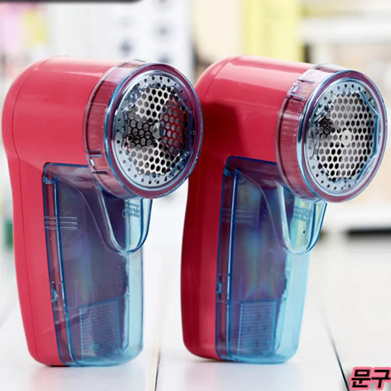 White portable electric lint remover for clothing on a table.