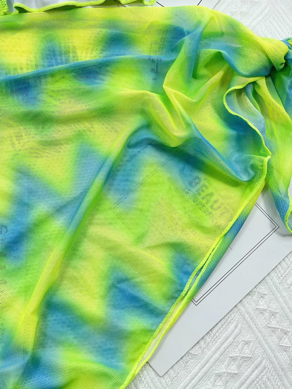 Green tie-dyed women's bikini swimsuit with detachable skirt on hanger