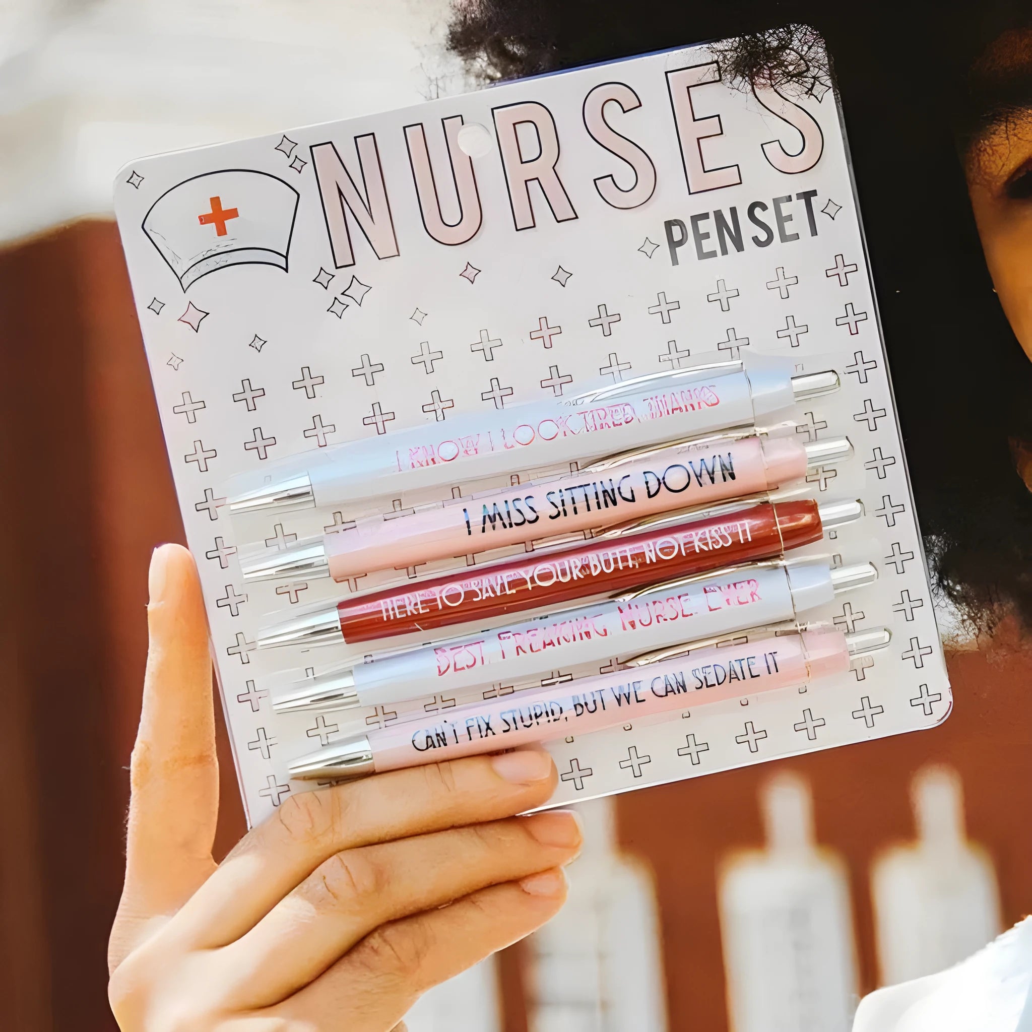 Five blue retractable ballpoint pens with white nurse-themed text, laid side by side.