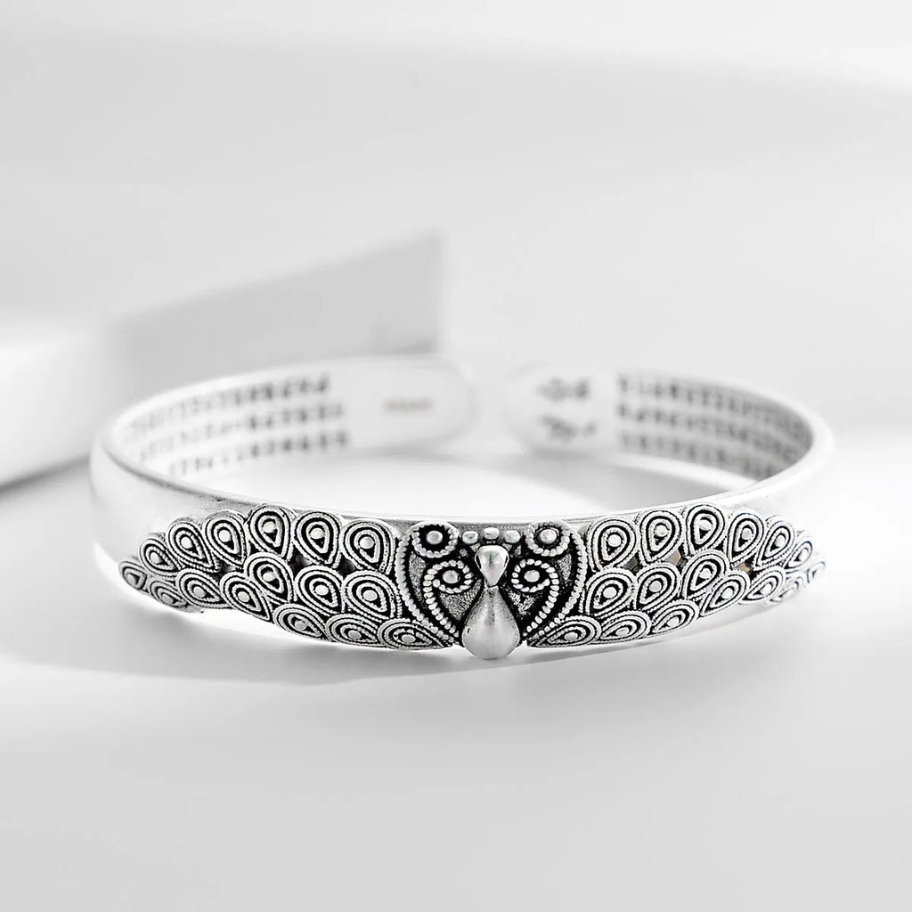 Antique copper plated silver bracelet with peacock open screen design on white background