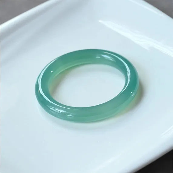 Natural agate wide tire bracelet shown in various colours including pink, blue, green and white agate.