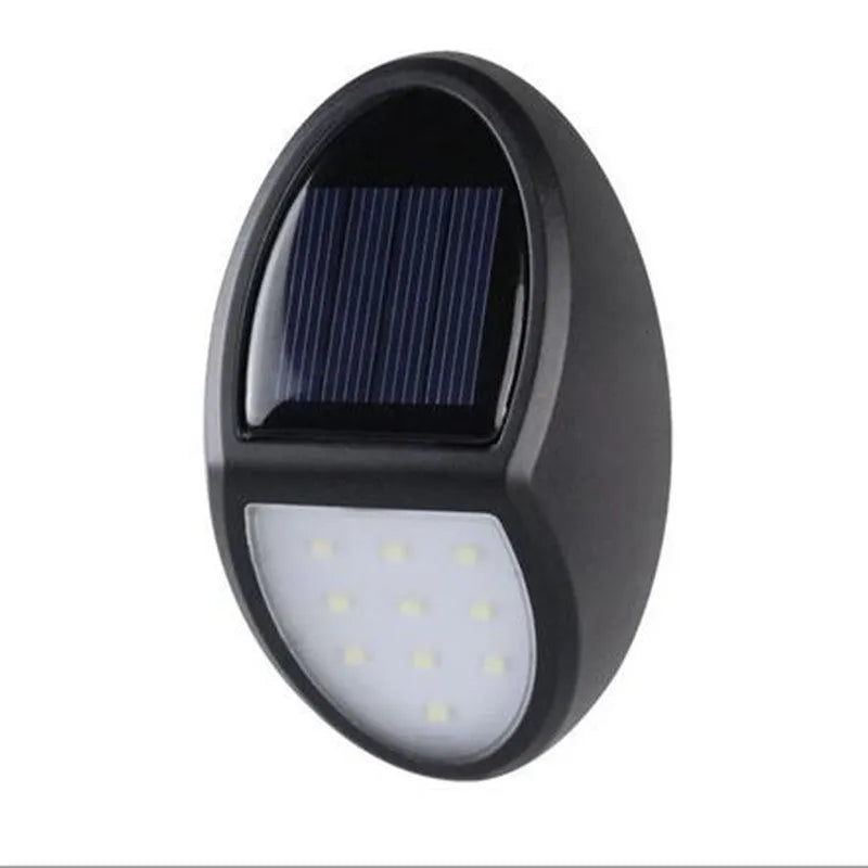 Black rectangular LED solar wall light with solar panel, shown mounted on an outdoor wall.