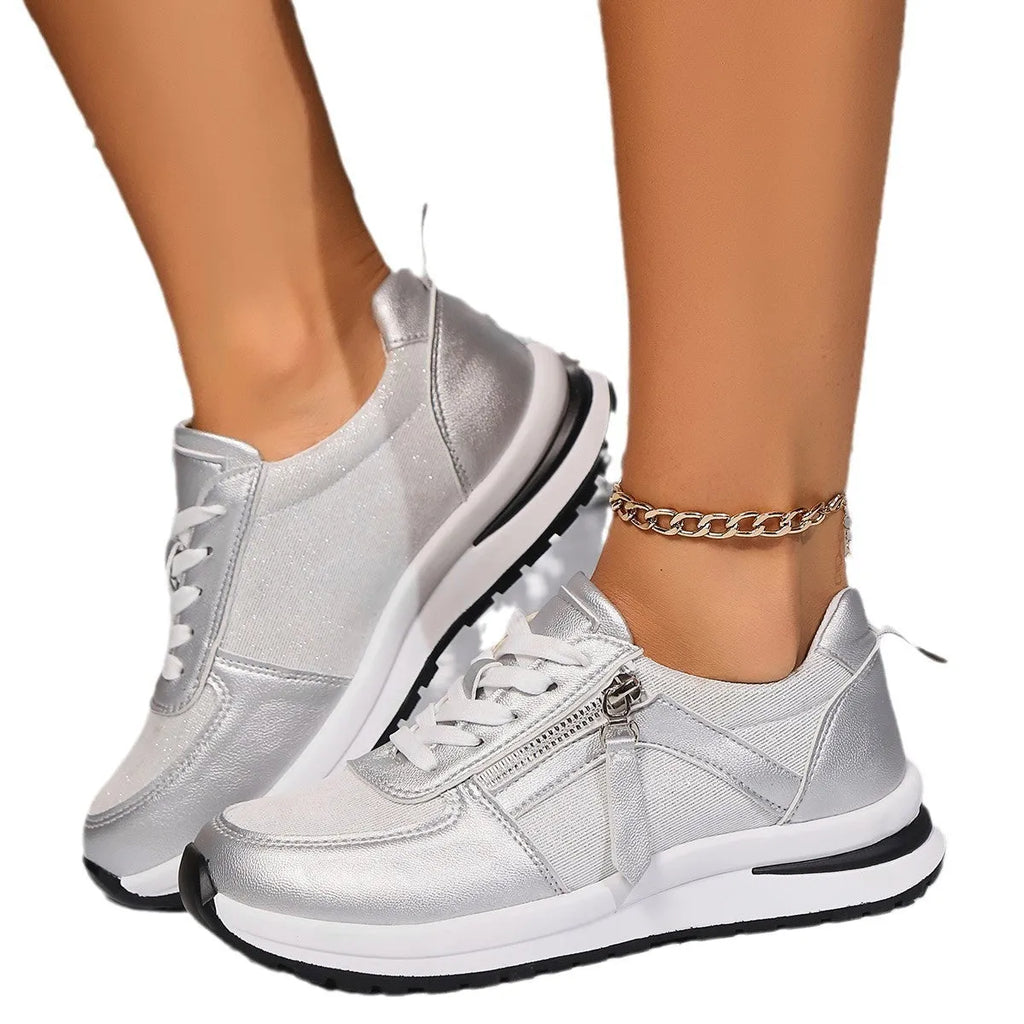 Gold women's lace-up pumps with round toe and flat rubber sole on a white background