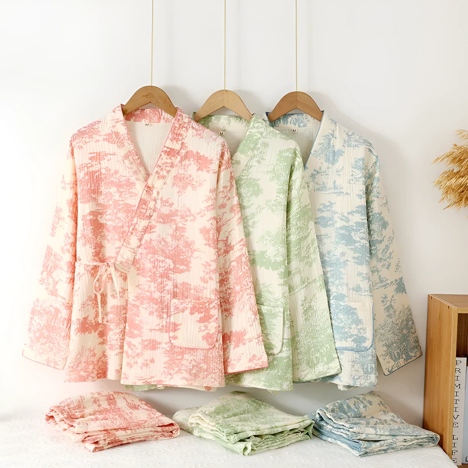 Women's pink cotton gauze lounge suit set with lace-up long sleeve top and matching trousers on a hanger.