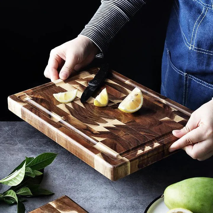 Brown parquet pattern solid acacia wood chopping board on a kitchen counter.