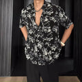 Loose fitting floral printed short sleeve shirt in black on a hanger