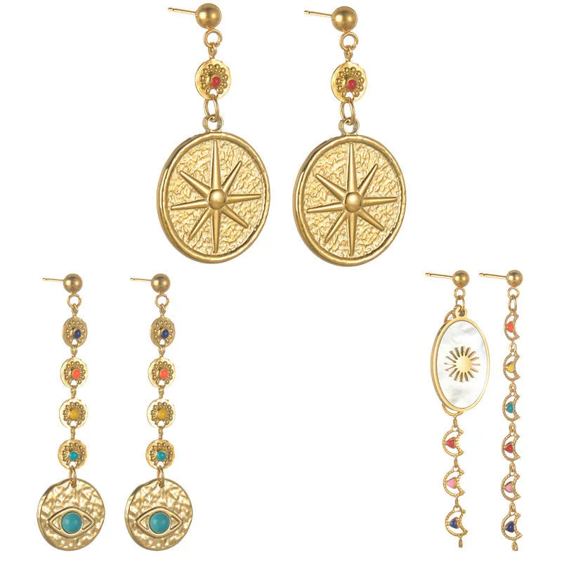 Three pairs of stainless steel geometry earrings: a star design, an eye design, and a shell sun design.