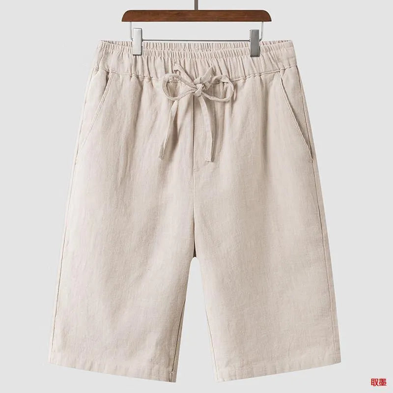 Man wearing beige loose-fit linen cropped shorts with an elastic mid waist.