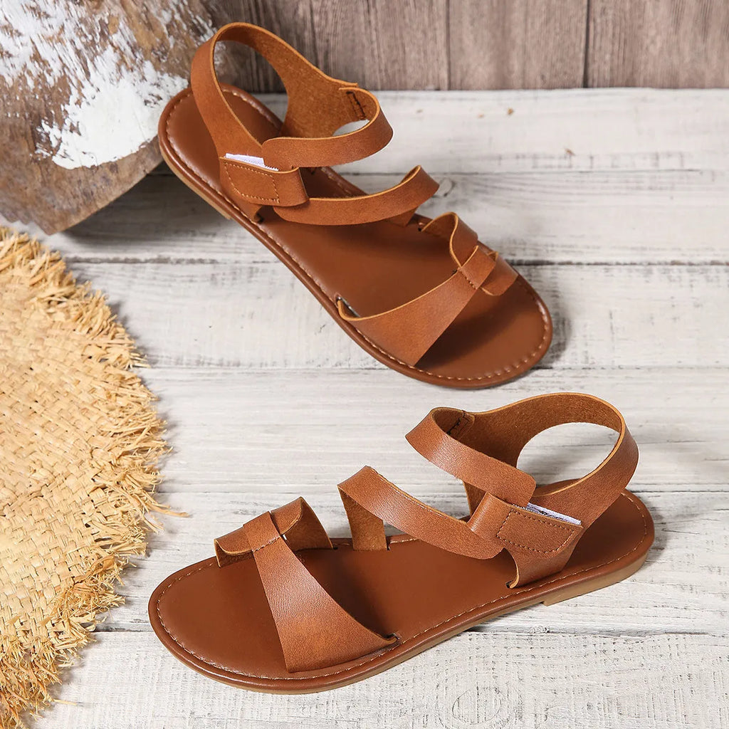 Women's flat sandals with Velcro strap in black, brown, and colourful options on a rubber sole.