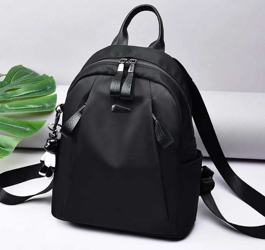 Medium-sized Oxford cloth rucksack in grey with double shoulder straps and a top handle.