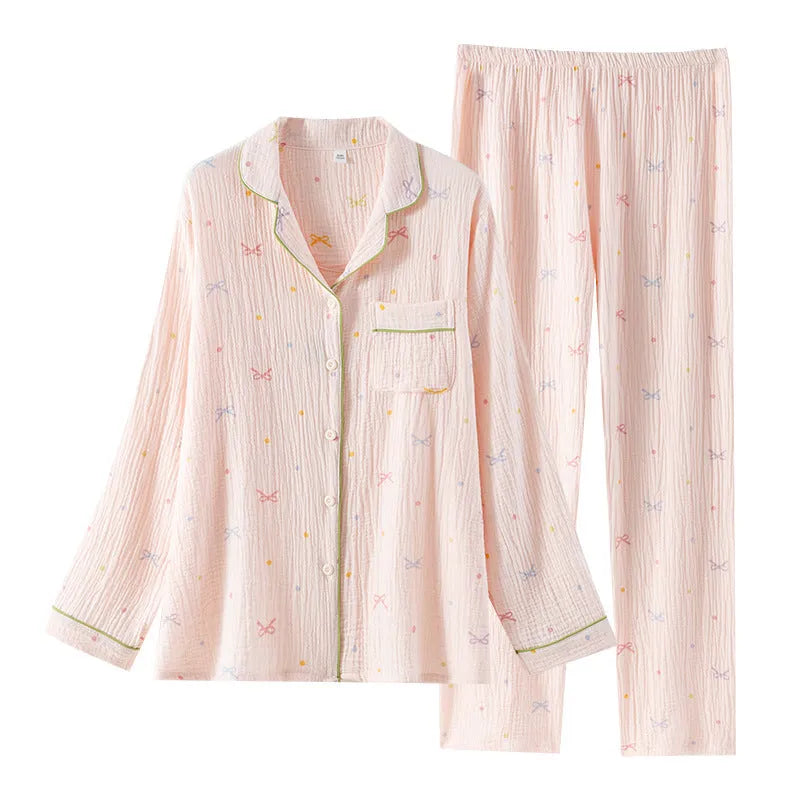 Women's pink cotton long-sleeved pajama top and trousers set laid flat.