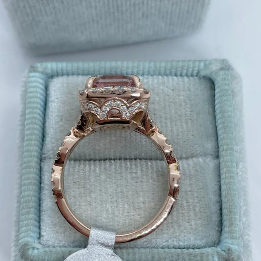 Geometric rose gold alloy ring on a plain background, showing its angular shape and metallic finish.