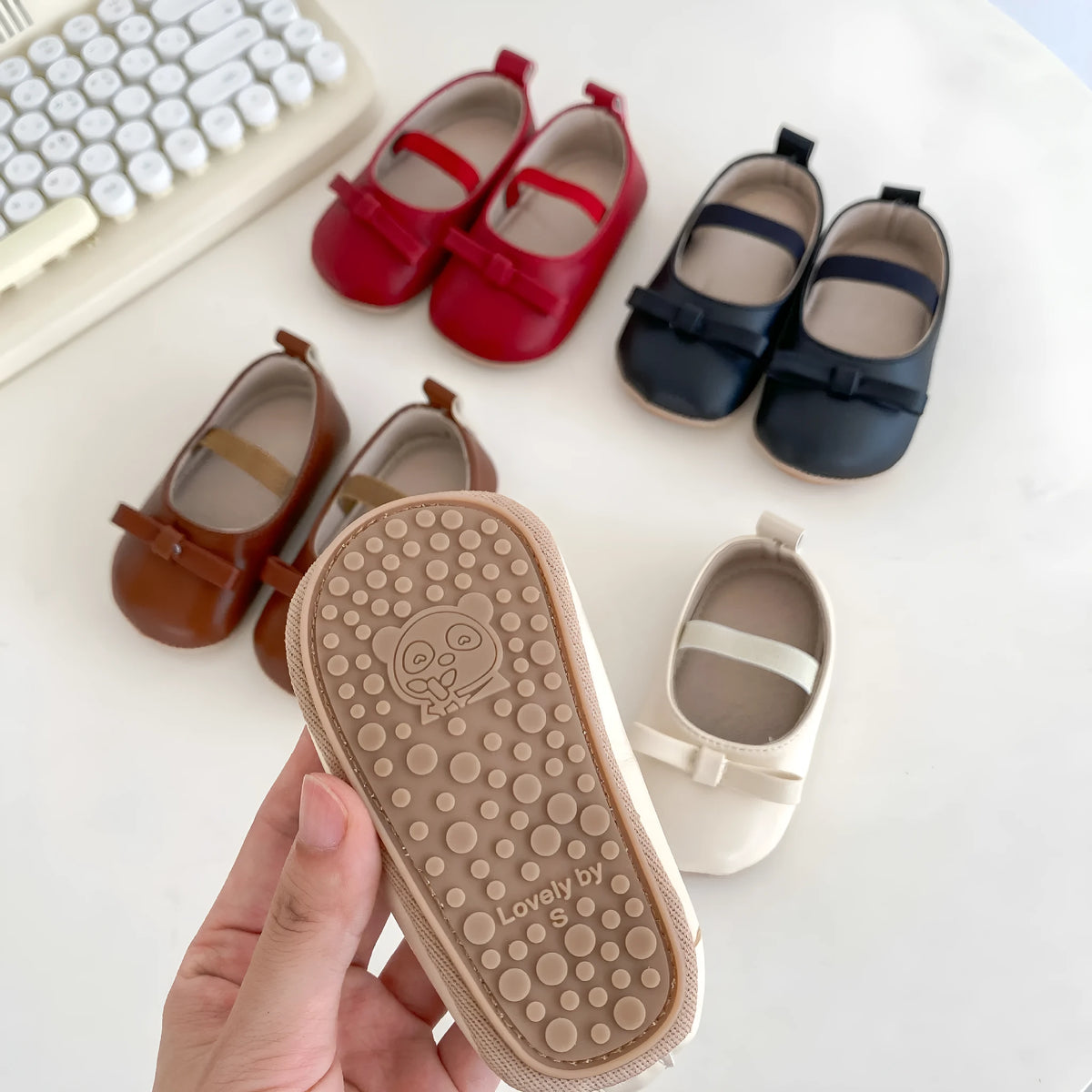 Baby girls' low top shoes with PU upper, rubber non-slip sole, bow detail, and elastic band, in black, white, chestnut brown, or red