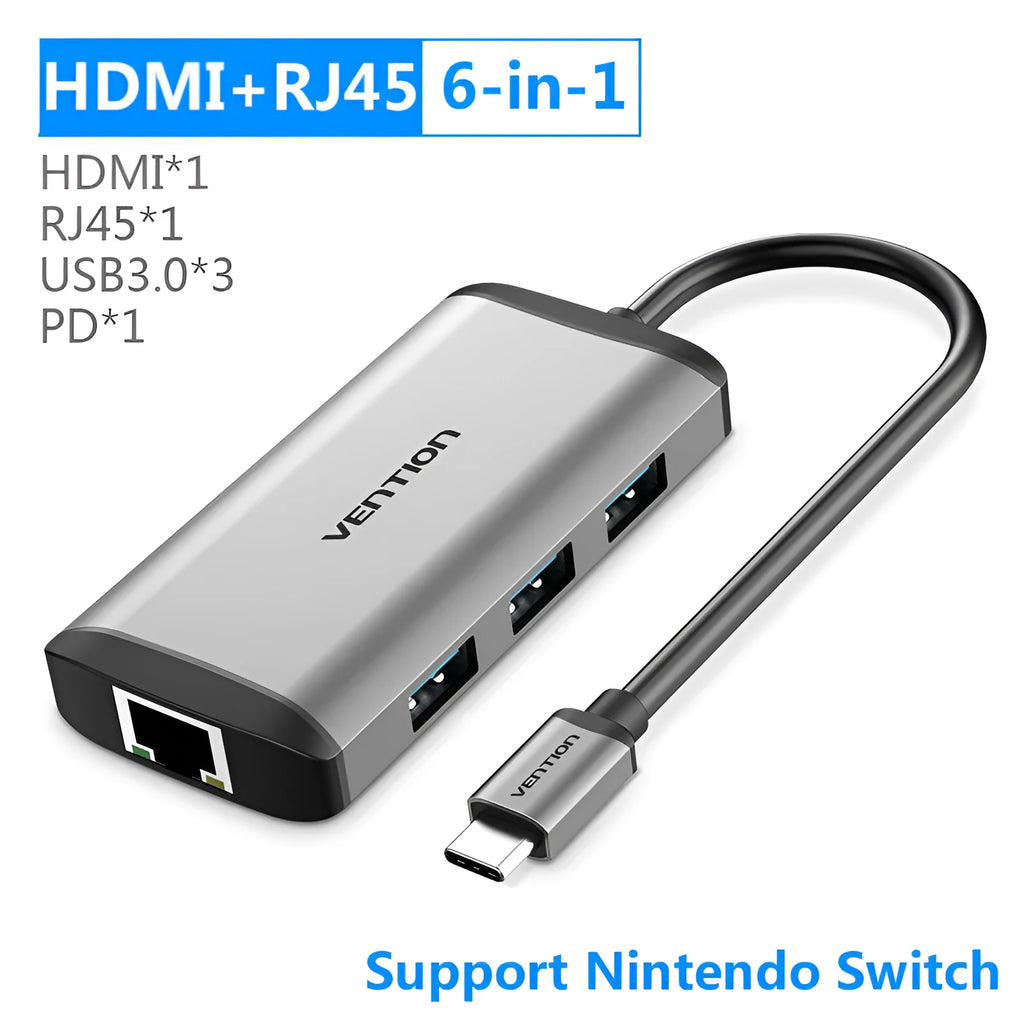Deep grey aluminium USB-C multi-port hub showing HDMI, USB, Ethernet, and memory card ports on a desk