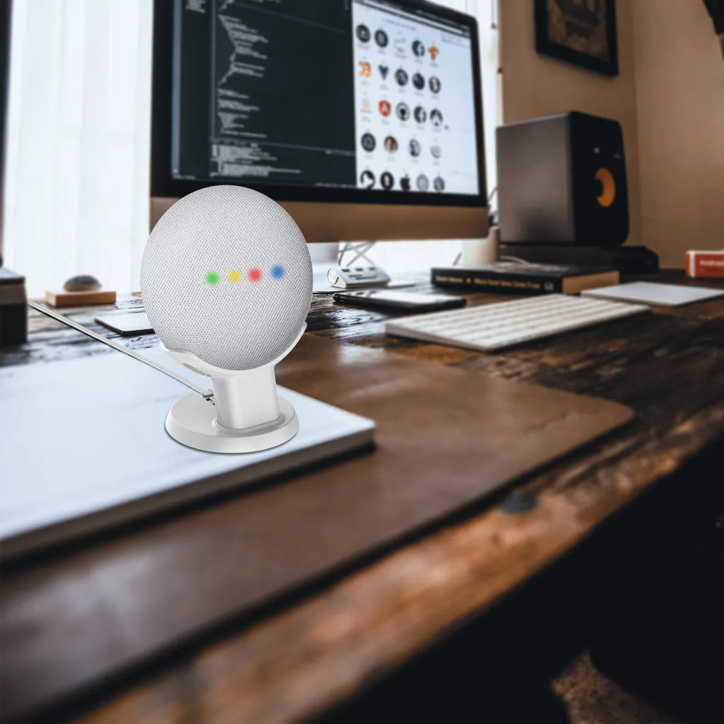 Black plastic Google Home Mini stand holder on a wooden desk